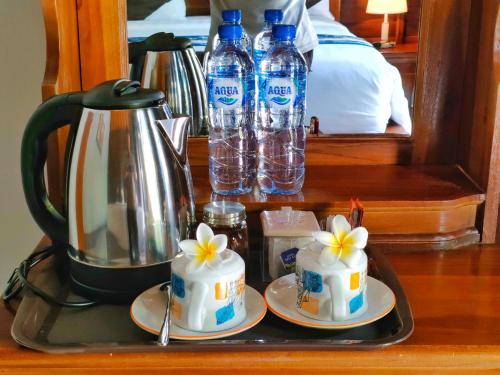 a tray with two cakes and bottles of water at Exotic View Cottage in Nusa Penida