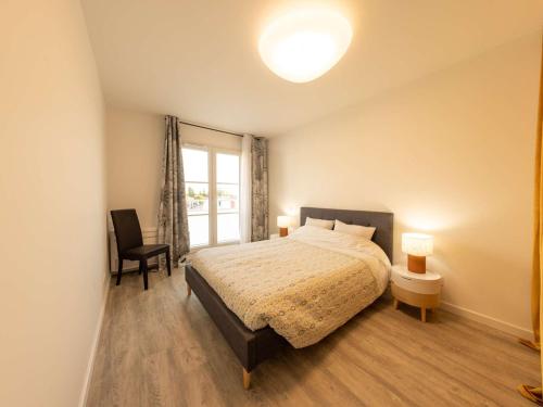 um quarto com uma cama, uma cadeira e uma janela em Appartement Saint-Pierre-d'Oléron, 3 pièces, 4 personnes - FR-1-246A-245 em Saint-Pierre-dʼOléron