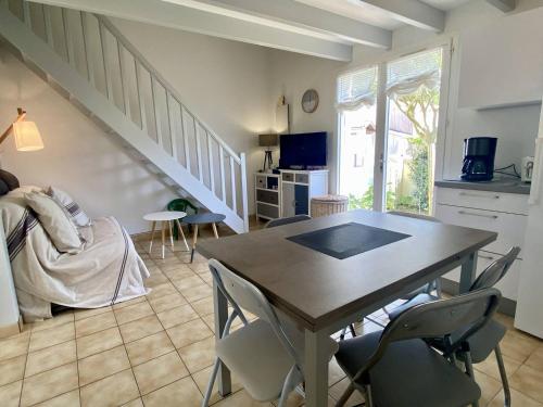 un salon avec une table et des chaises et un escalier dans l'établissement Maison Familiale à 100m de la Plage – Terrasse, Jardin, 6 Couchages, Parking Gratuit - FR-1-246A-246, à Dolus-d'Oléron