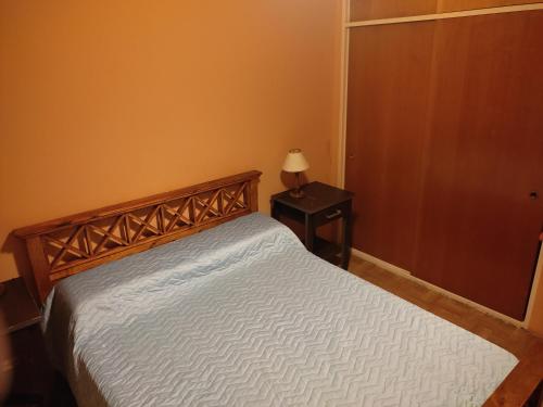 a bedroom with a bed and a table with a lamp at Departamento 2 Habitaciones in Rosario