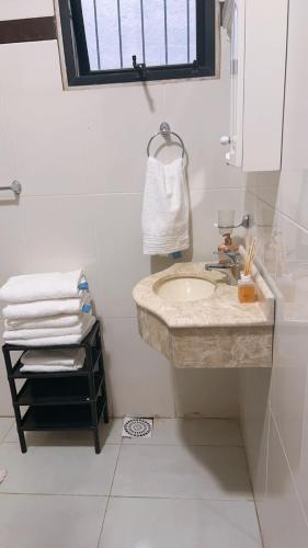 uma casa de banho com lavatório, espelho e toalhas em Roli em Clorinda