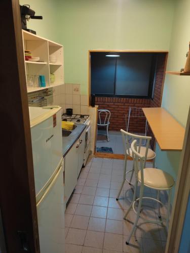 a kitchen with white appliances and a table and chairs at Departamento 2 Habitaciones in Rosario