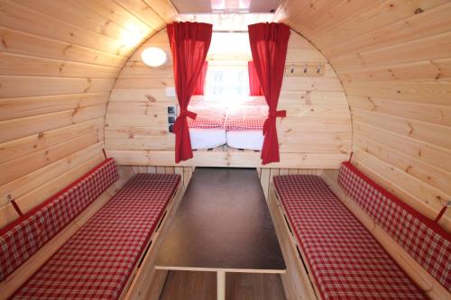 Habitación pequeña con bancos rojos y ventana en AZUR Camping Wertheim en Wertheim