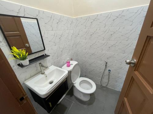 a bathroom with a white toilet and a sink at King's Cottage Homestay Kubang Kerian in Kota Bharu