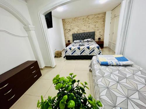 1 dormitorio con 2 camas y planta en Suite in the exclusive area of San Marino, en Guayaquil