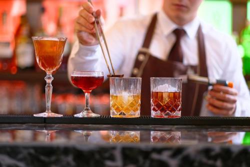 a bartender is preparing three different types of drinks at Augustine, a Luxury Collection Hotel, Prague in Prague