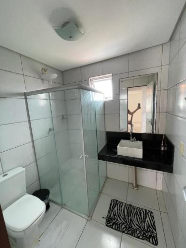 a bathroom with a toilet and a sink and a mirror at Vista Real - cobertura com 160m2 - Piscina privada in João Pessoa