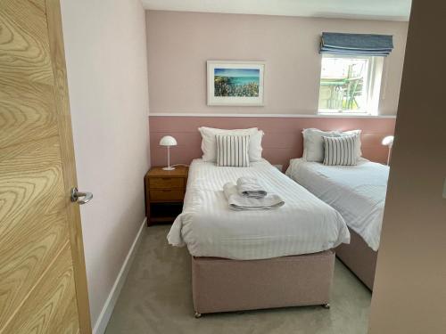 a bedroom with two beds and a window at The Old Coastguard Lookout in Port Isaac