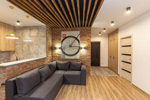 a living room with a couch and a brick wall at Brick Apart Melnyka10 in Ivano-Frankivsʼk