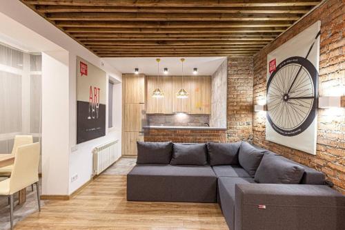 a living room with a couch and a brick wall at Brick Apart Melnyka10 in Ivano-Frankivsʼk