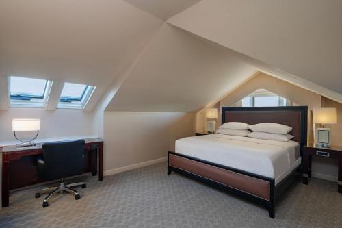 a bedroom with a bed and a desk and a chair at Sheraton Portsmouth Harborside Hotel in Portsmouth
