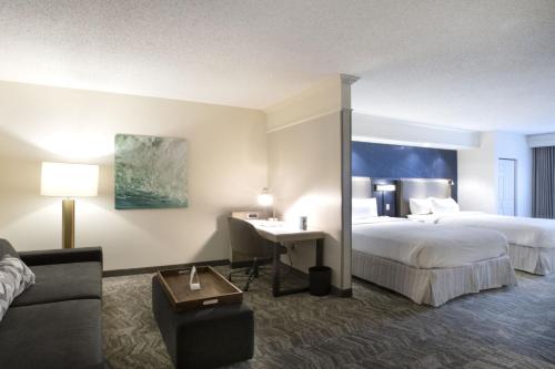 サバンナにあるSpringHill Suites Savannah Airportのベッド2台とデスクが備わるホテルルームです。