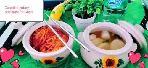 a table with two bowls of food with chopsticks in it at New Garden View GF Double Room FREE parking in Batu Unjor