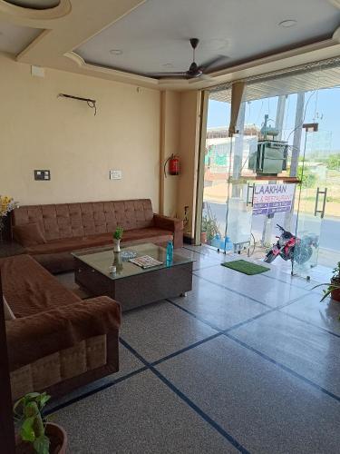 a living room with a couch and a coffee table at Hotel LAAKHAN BY GHUMO UDAIPUR in Udaipur