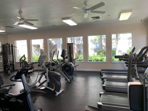 einen Fitnessraum mit Laufbändern und Crosstrainern in der Unterkunft Stress Free Living 3br 2ba in Orlando