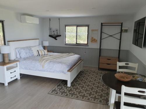 Lowden的住宿－Preston Valley Retreat，卧室配有一张床和一张桌子及椅子