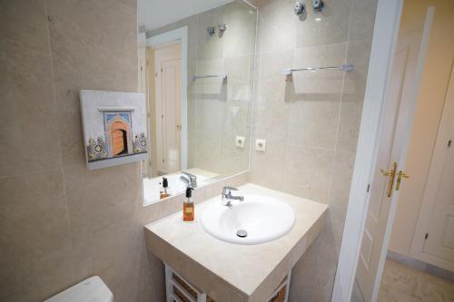 y baño con lavabo, espejo y aseo. en Cozy Apartment in Puerto Banus, en Marbella