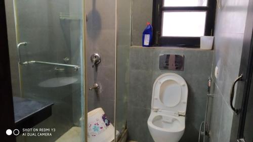 a small bathroom with a toilet and a window at Blessings Noida Home stay in Noida