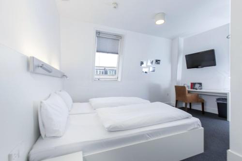 a white room with a bed and a desk at mk hotel london in London