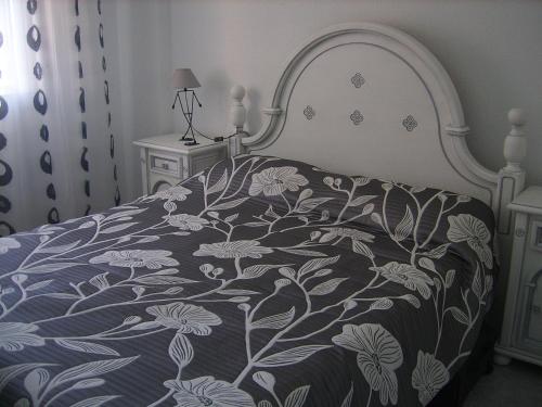 トレビエハにある1th line Apartment playa del curaのベッド(花の上に青と白のベッドカバー付)