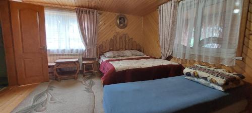a bedroom with two beds and a window at Біля Погару in Slavske
