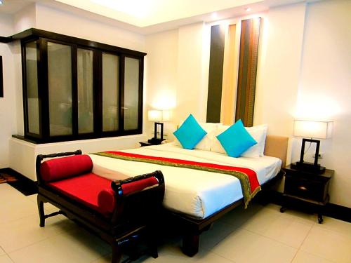 a bedroom with a large bed and a red chair at Yantarasri Resort in Chiang Mai