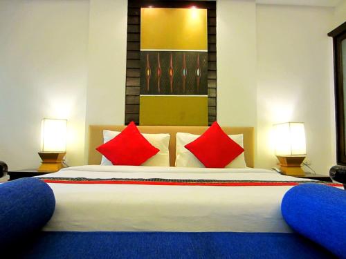 a bedroom with a large bed with red pillows at Yantarasri Resort in Chiang Mai