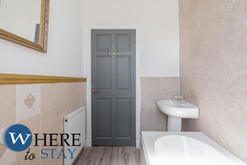 a bathroom with a blue door and a sink at Apartment beyond forth Bridges - 3bed free parking in Inverkeithing