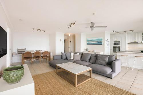uma sala de estar com um sofá e uma mesa em Rainbow Commodore Coolangatta em Gold Coast