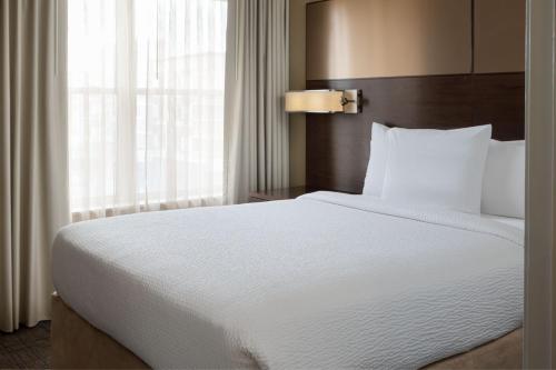 a large white bed in a hotel room with a window at Residence Inn Largo Medical Center Drive in Largo