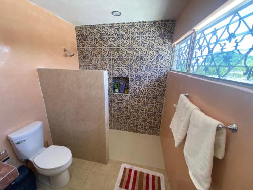 a bathroom with a toilet and a window at Casa del artista in Mérida
