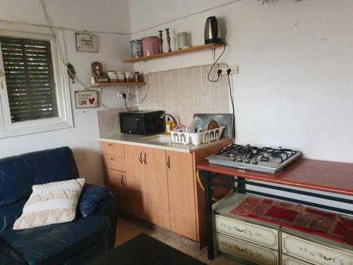 a small kitchen with a stove and a couch at 2 bedroom apartment in batiya makov in Rechovot