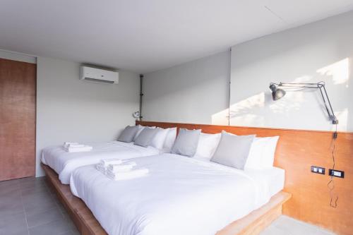 a bedroom with a large white bed with white pillows at GalileOasis Boutique Hotel in Bangkok