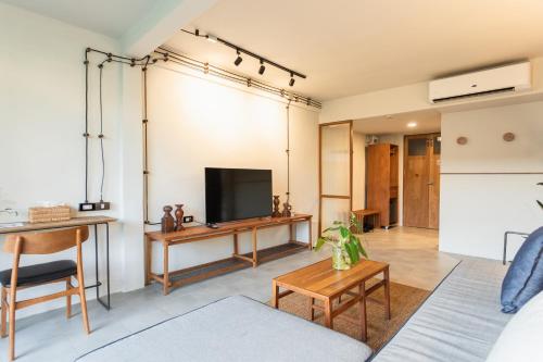a living room with a tv and a couch at GalileOasis Boutique Hotel in Bangkok