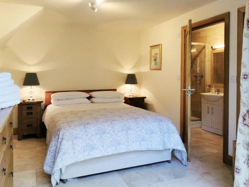 a bedroom with a large bed and a bathroom at Green Acre Lodge in Tatterford