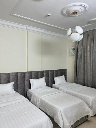 two beds in a room with white sheets at بيوتي روز لشقق المخدومه in Abha
