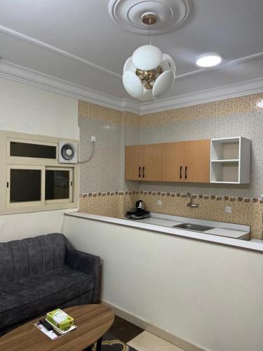 a living room with a couch and a kitchen at بيوتي روز لشقق المخدومه in Abha