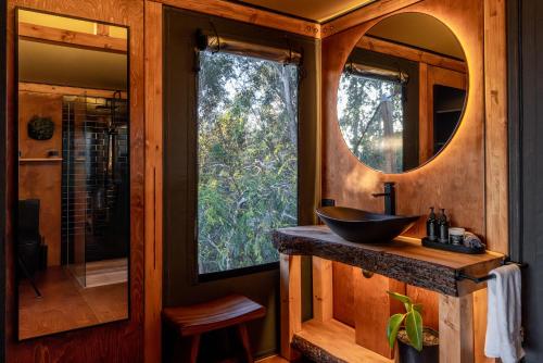 a bathroom with a sink and a mirror at The Enchanted Retreat - Unforgettable Luxury Glamping in Havelock North