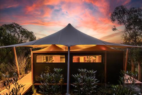 une tente avec un coucher de soleil en arrière-plan dans l'établissement The Enchanted Retreat - Unforgettable Luxury Glamping, à Havelock North