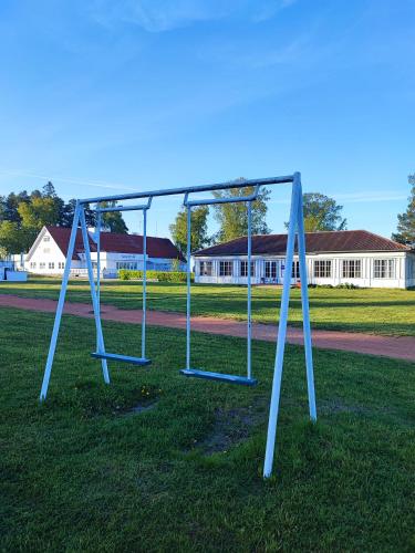 an empty swing set in the grass in a park at Lainela puhkeküla in Käsmu