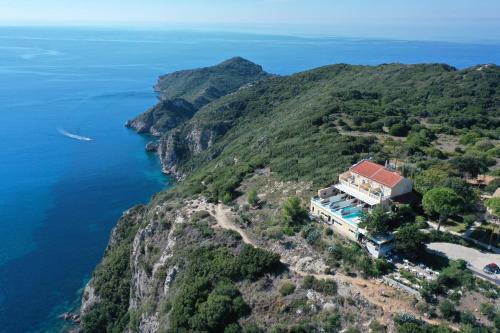 an aerial view of a house on a cliff next to the water at Zeus Throne Suites in Afionas