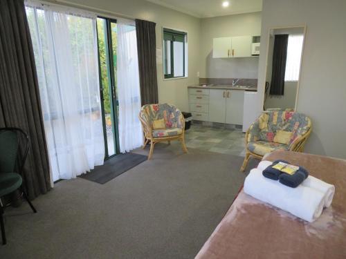 a living room with two chairs and a table at Commodore Court Motel in Blenheim
