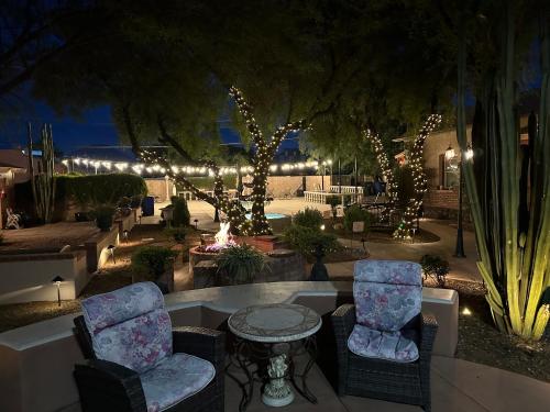 a patio with two chairs and a table and lights at El Amador Inn Downtown Tucson in Tucson