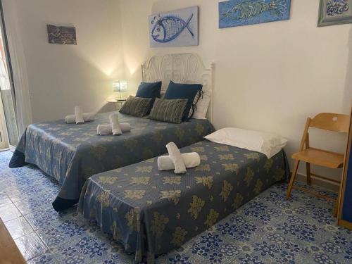 um quarto com 2 camas e uma cadeira em Vic e Vicariell em Gaeta