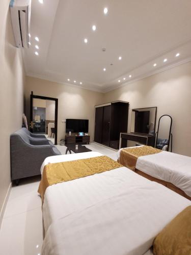 a hotel room with three beds and a flat screen tv at لاكازا للشقق المخدومة in Riyadh