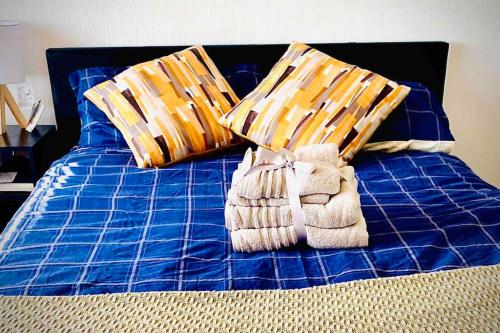 uma cama azul com duas almofadas e toalhas em Hare view Cottage - Northumberland 