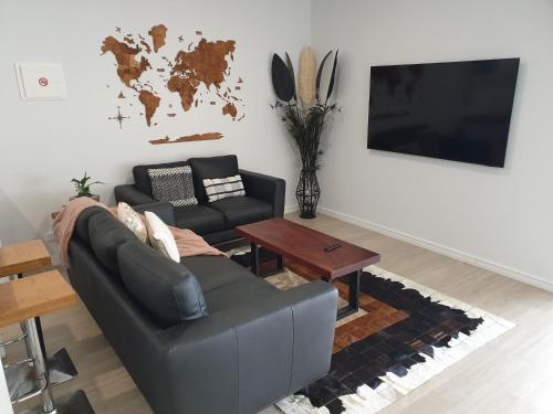 a living room with a couch and a table at Preston Valley Shed Stay in Lowden