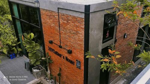 un edificio de ladrillo con plantas a su lado en Mother’s House(บ้านแม่) en Wang Saphung