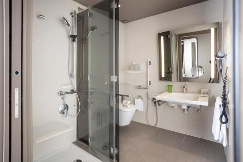 a bathroom with a shower and a toilet and a sink at 8Piuhotel in Lecce