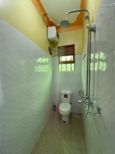 a bathroom with a toilet and a shower at Ntebeko Homestay in Kisoro